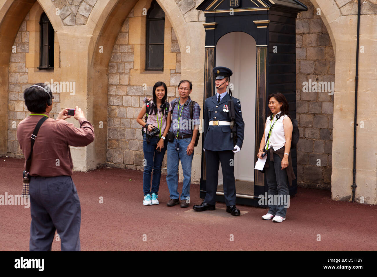 L'Angleterre, Berkshire, Windsor, Castle Hill, oriental touristes posant avec Royal Air Force Regiment guardsman Banque D'Images