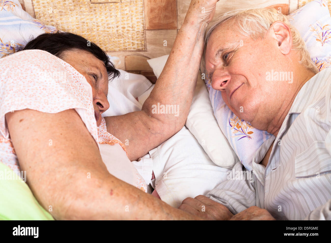 Détail de senior couple relaxing in bed. Banque D'Images