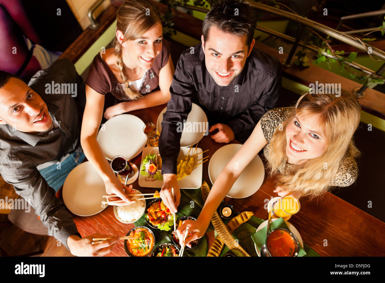 Les jeunes de manger dans un restaurant thaïlandais, ils mangent avec des baguettes Banque D'Images