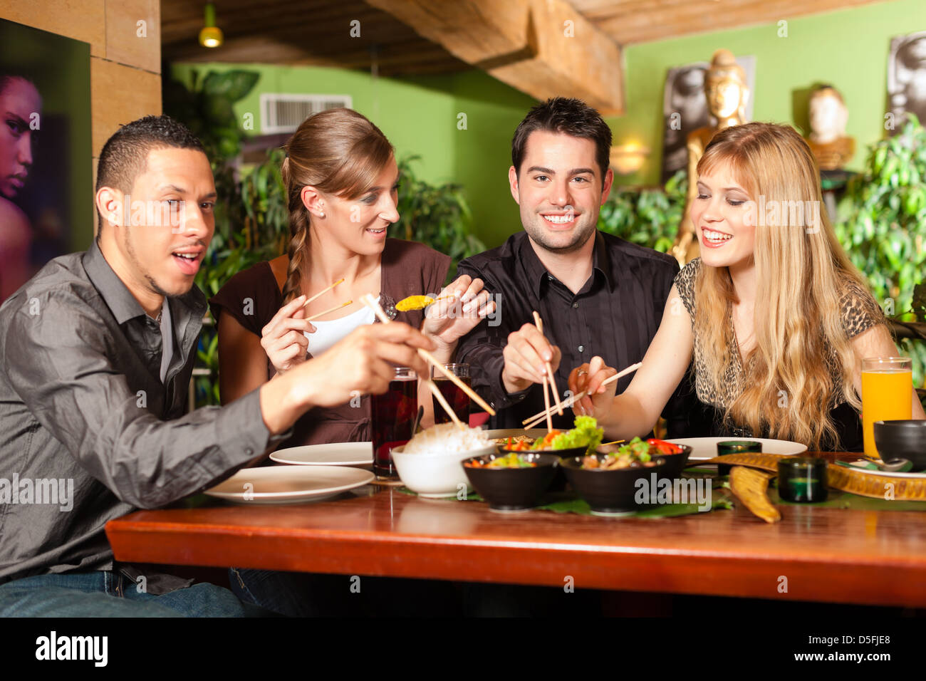 Les jeunes de manger dans un restaurant thaïlandais, ils mangent avec des baguettes Banque D'Images