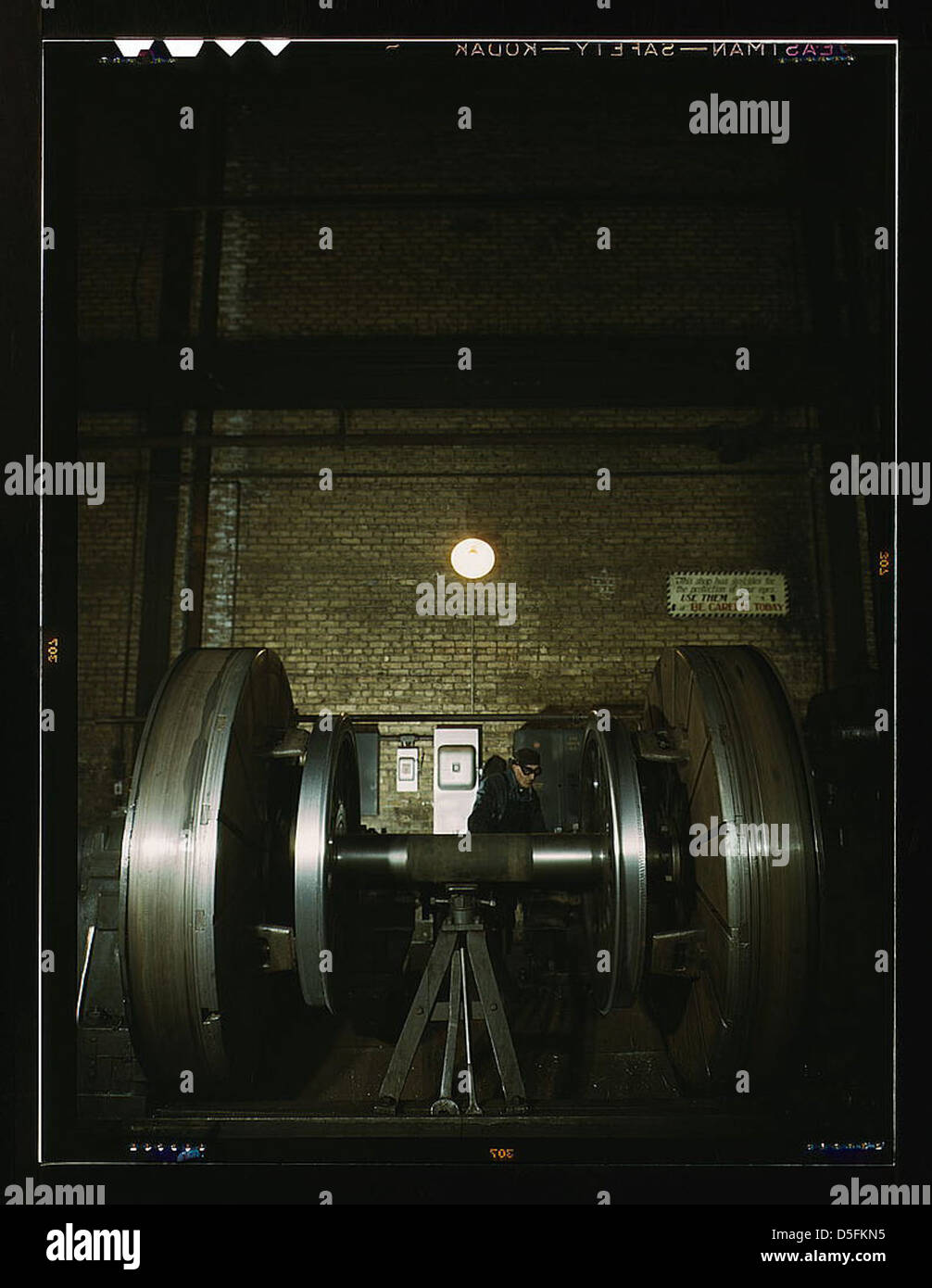 Une machine d'atelier de roues est utilisée pour réparer les pneus de locomotive usés au Chicago and Northwestern Railroad en 1942, présentant la maintenance industrielle et les opérations ferroviaires. Banque D'Images