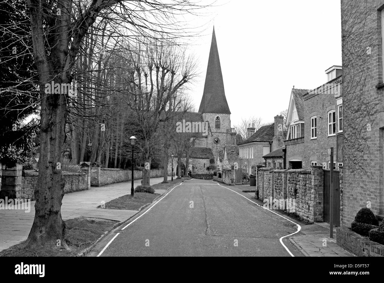 Une image en noir et blanc d'une rue bordée d'arbres menant à l'église St Mary à l'arrière-plan Horsham Sussex England Banque D'Images