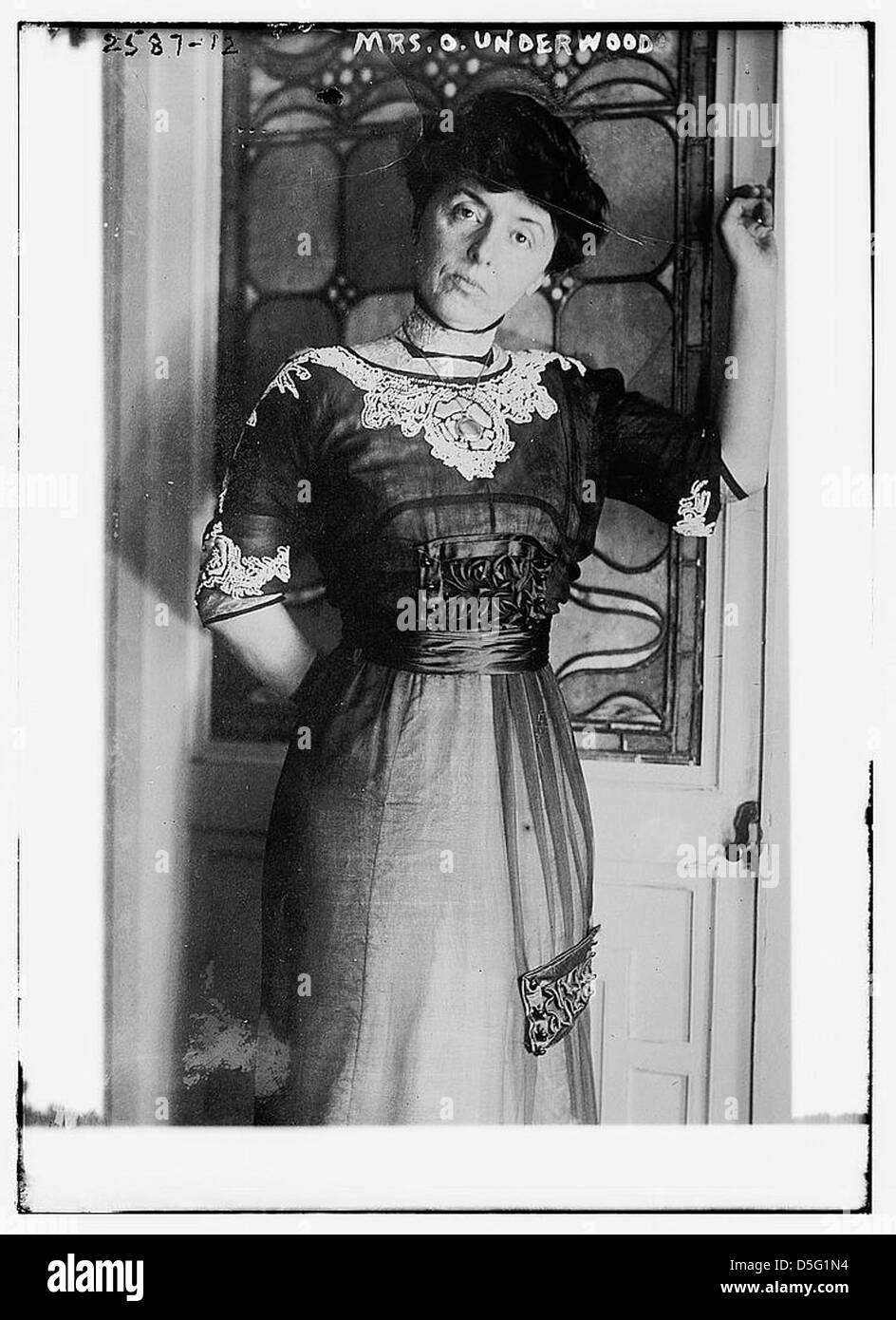 Une photographie du début des années 1900 montre MRS Oscar W. Underwood portant une robe en dentelle, avec un vitrail en arrière-plan. Cette image met en valeur la mode et la vie sociale au début du XXe siècle. Banque D'Images