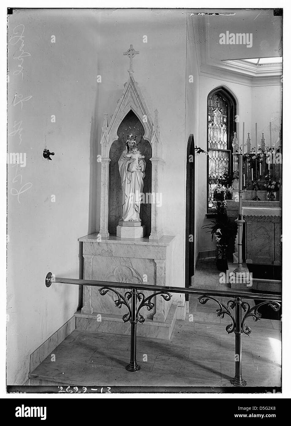 La chapelle du Saint-enfant est représentée sur cette photographie en noir et blanc, mettant en valeur sa statuaire religieuse et ses caractéristiques architecturales. L'image capture la beauté solennelle de ce lieu de culte, mettant l'accent sur les statues complexes qui représentent la foi chrétienne et la spiritualité. Banque D'Images