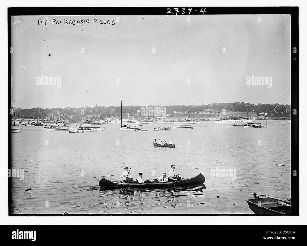 Cette image montre quatre hommes dans un canot lors d'une course à po'k'psie sur la rivière Hudson à New York. La photo montre les athlètes en action, soulignant l'athlétisme collégial et la culture compétitive de l'aviron de 1913. Banque D'Images