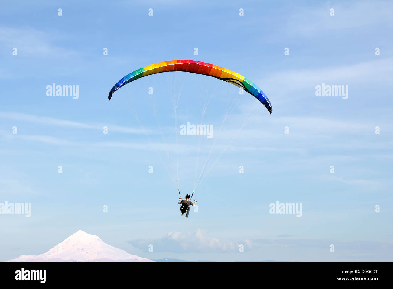 Parapente sur le mont Hood avec parachute de couleur arc-en-ciel contre Ciel Bleu Banque D'Images