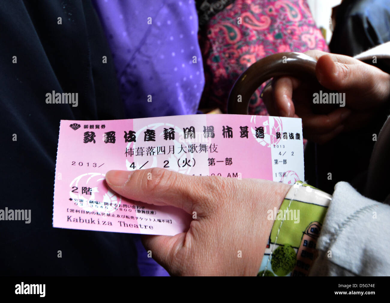 Le 2 avril 2013, Tokyo, Japon - Avec le ticket dans sa main, une femme  attend pour l'ouverture de la nouvelle version de théâtre Kabuki de Tokyo,  shopping-divertissement de Ginza, le mardi,