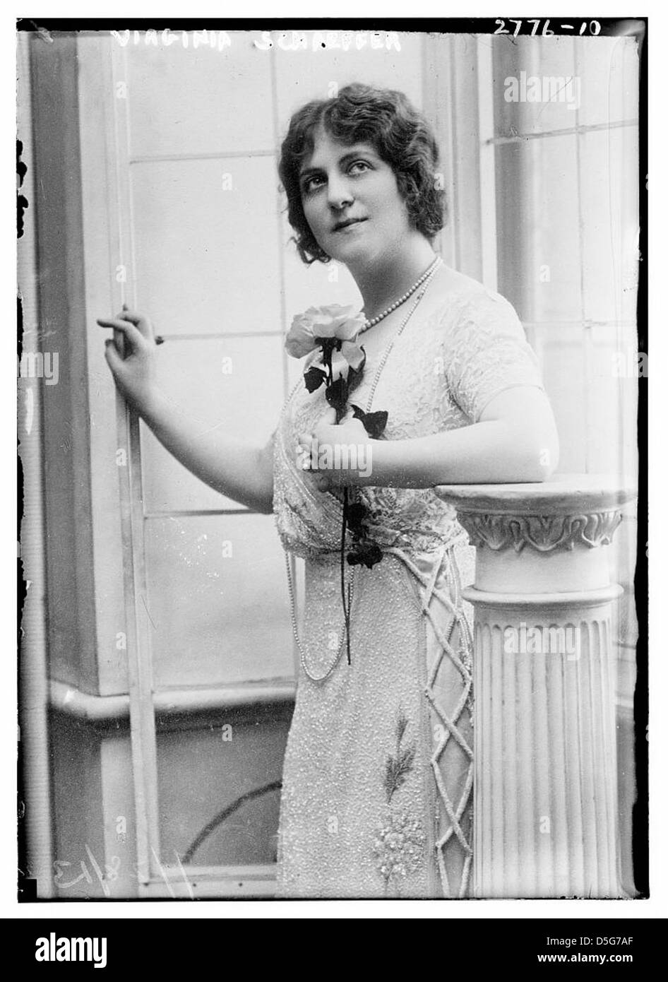 Un portrait de Virginia Schaeffer, pris le 28 juillet 1913, la montrant posant avec une fleur. L'image est un exemple emblématique du portrait du début du XXe siècle, mettant en valeur l'élégance et l'importance historique de Schaeffer. Banque D'Images