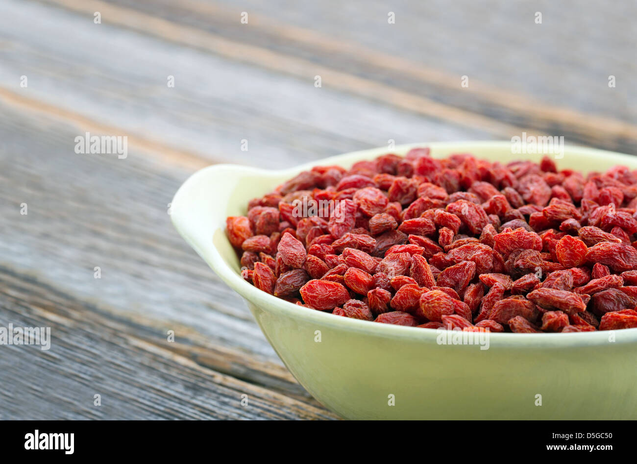 Baies de goji rouge sur fond de bois rustique Banque D'Images