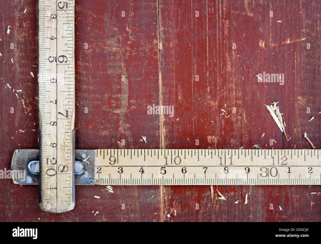 Ancienne en bois mètre vintage sur fond de bois rouge - Notion de bricolage Banque D'Images