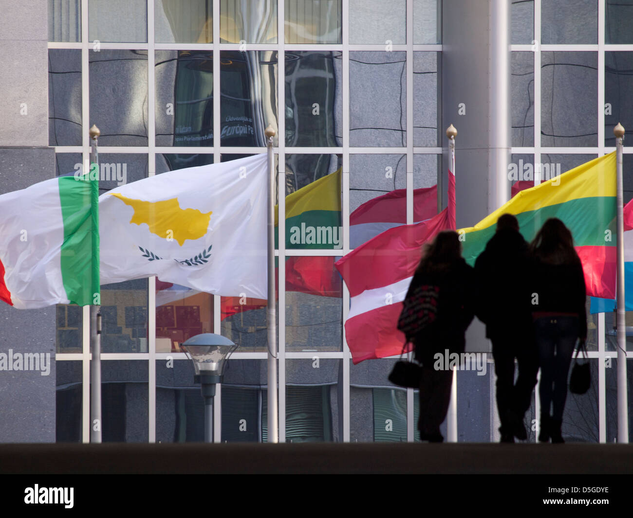 Divers Drapeaux des États membres de l'UE à Bruxelles, Belgique avec la silhouette du groupe de personnes marcher Banque D'Images