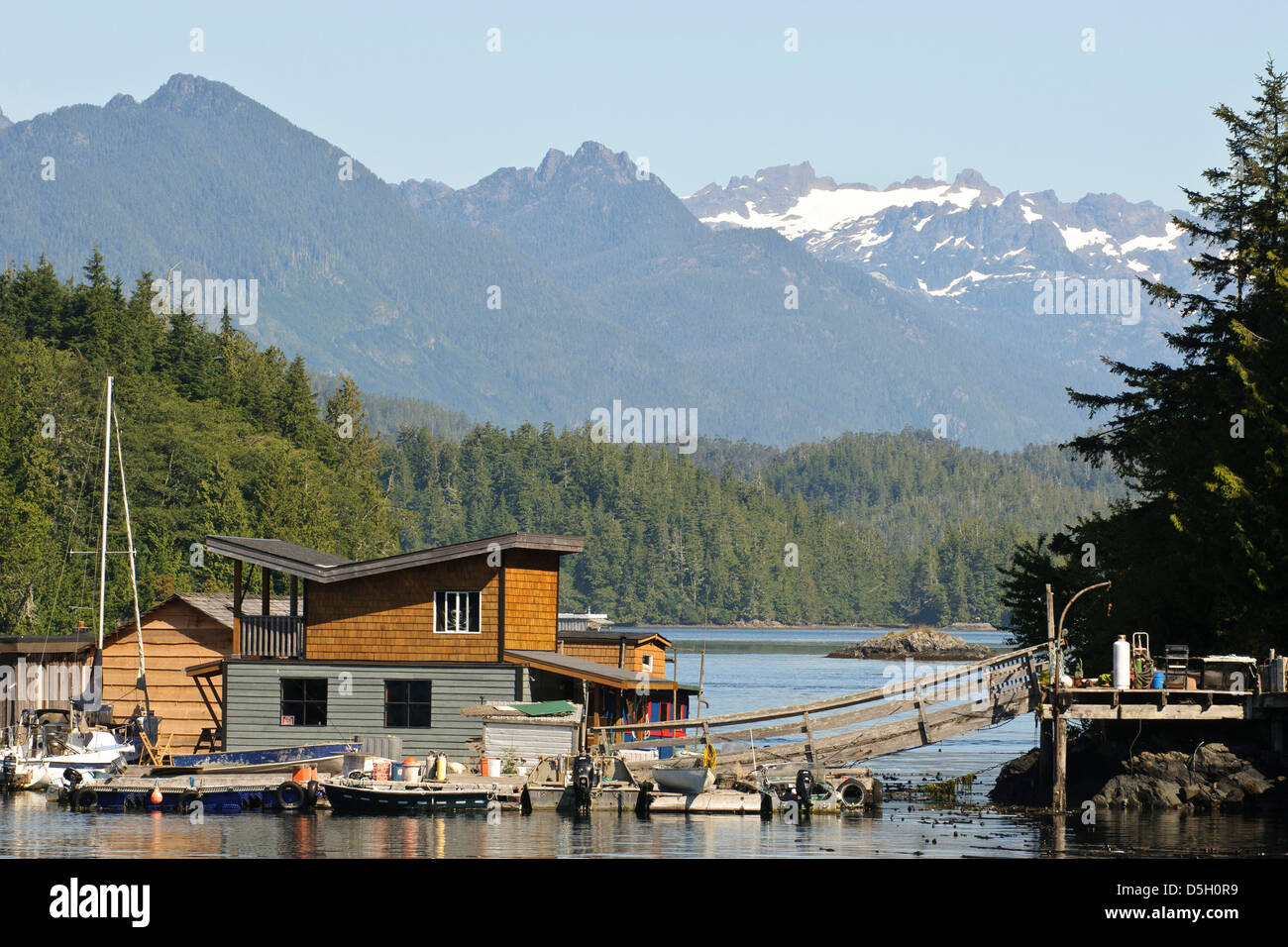 L'île de Vancouver, Tofino. Maisons flottantes en face des montagnes du parc provincial Strathcona. Banque D'Images