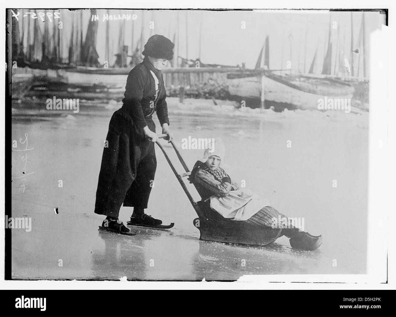 Une femme vêtue d'un costume traditionnel et de patins à glace est photographiée en Hollande. L'image met en valeur la tenue culturelle néerlandaise et le sport d'hiver du patinage sur glace, mettant l'accent sur les coutumes traditionnelles de la région. Banque D'Images