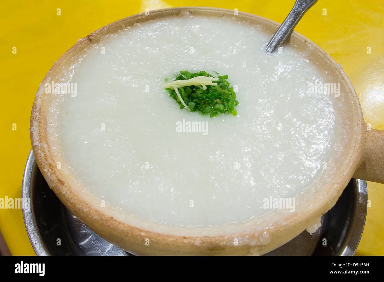 Claypot congee chinois du porridge avec la ciboulette et le gingembre closeup Banque D'Images