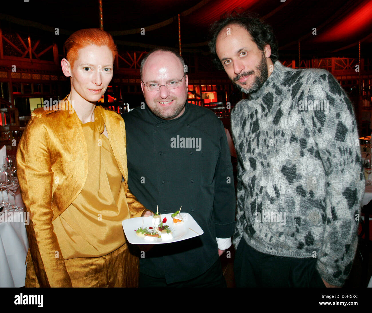 L'allemand chef primé Chrsitian Lohse (C) sert un plat à l'actrice britannique Tilda Swinton (L) et réalisateur italien Luca Guadagnino lors d'événement de cinéma culinaire dans le champ d'application de la 60e Berlinale Festival International du Film de Berlin, Allemagne, 14 février 2010. La 60e Berlinale s'exécute jusqu'au 21 février. Photo : Xamax Banque D'Images