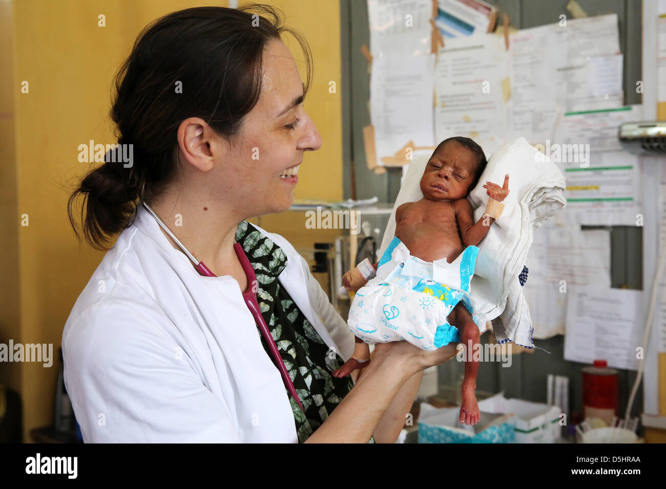 Femme médecin allemand examining newborn bébé africain. Hôpital de Techiman, Ghana Banque D'Images