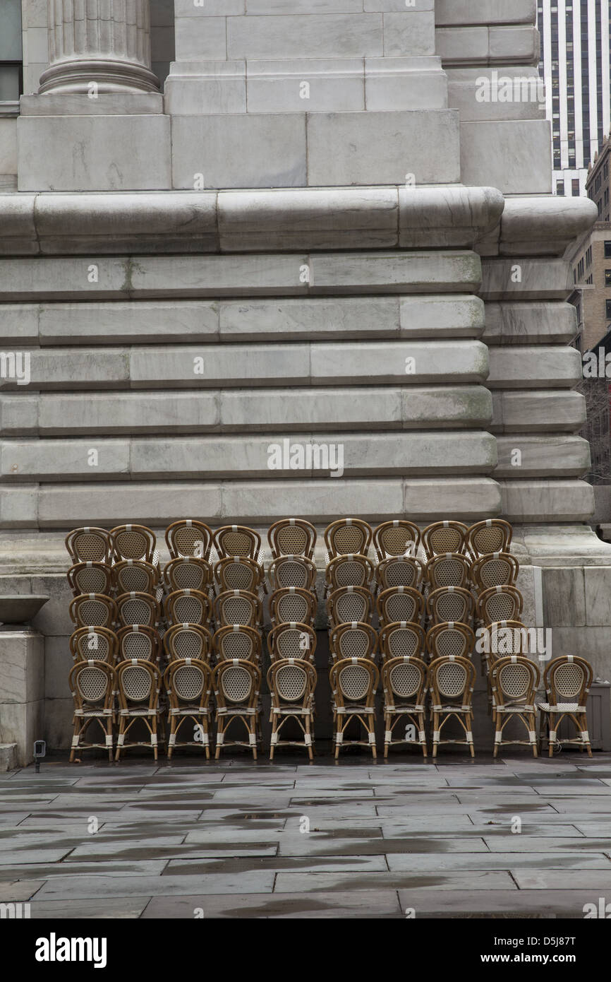 Café chaises empilées au Bryant Park derrière la Bibliothèque publique de New York à Manhattan Banque D'Images