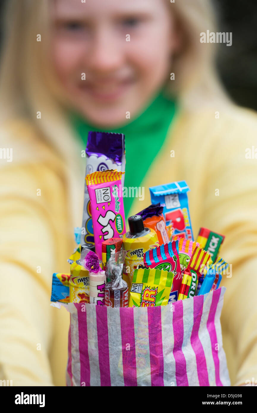 Girl holding un sac d'assortiment de bonbons et sucreries rétro pour enfants Banque D'Images