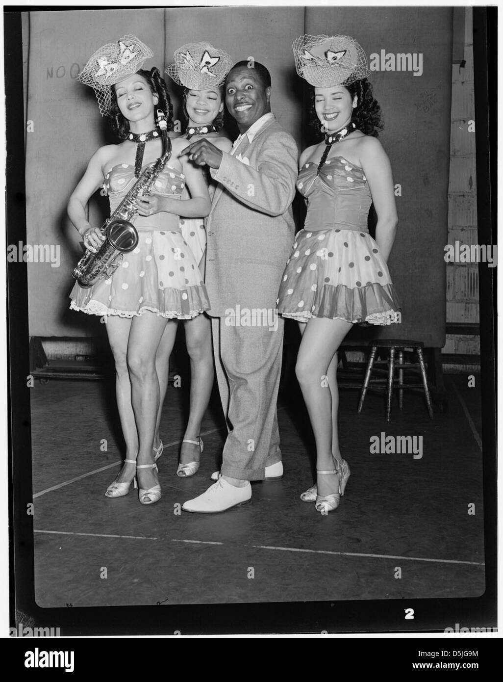 Ce portrait de juillet 1946 montre Louis Jordan, un célèbre musicien américain, se produisant au Paramount Theater de New York. Connu pour son influence dans le développement du rythme et du blues, cette image capture la présence de Jordan dans le monde du divertissement. Banque D'Images