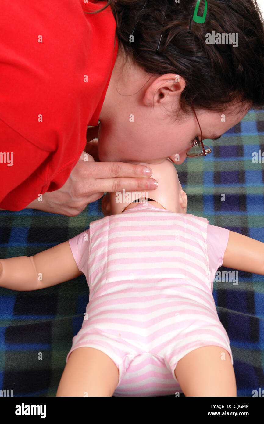 Instructeur de secourisme démontrant la respiration artificielle à l'aide de mannequin nourrisson Banque D'Images