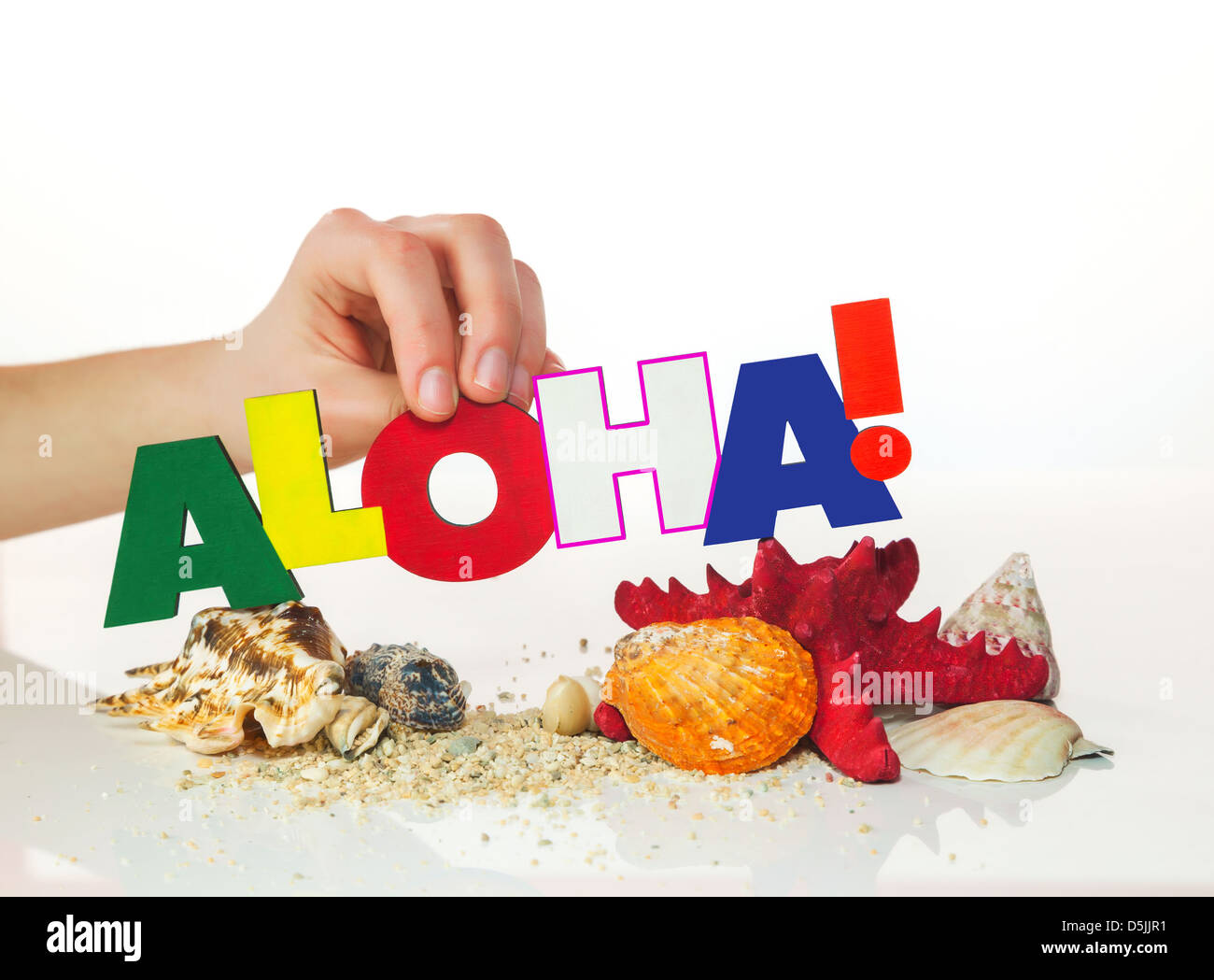 Femme's hand holding colorful mot 'Aloha' against white background Banque D'Images