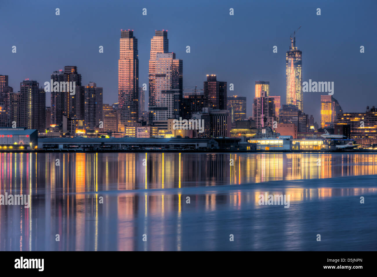 Bâtiments sur le côté ouest de Manhattan et leurs réflexions sur la Rivière Hudson au cours de la dernière heure avant le lever du soleil. Banque D'Images