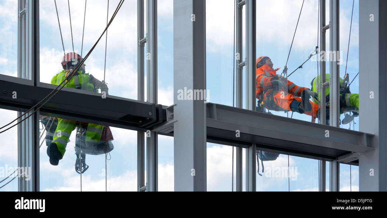 Sur des cordes suspendues sur face extérieure d'un bâtiment en forme de tour de Londres d'effectuer des travaux de maintenance Banque D'Images