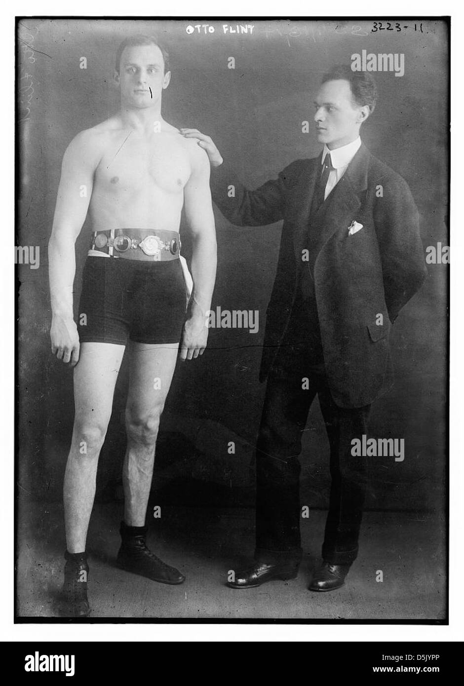 Une photographie d'Otto Flint, un boxeur, capturé en action lors d'un match. L'image souligne son athlétisme et sa détermination, mettant en valeur le sport de la boxe au début du XXe siècle. Banque D'Images