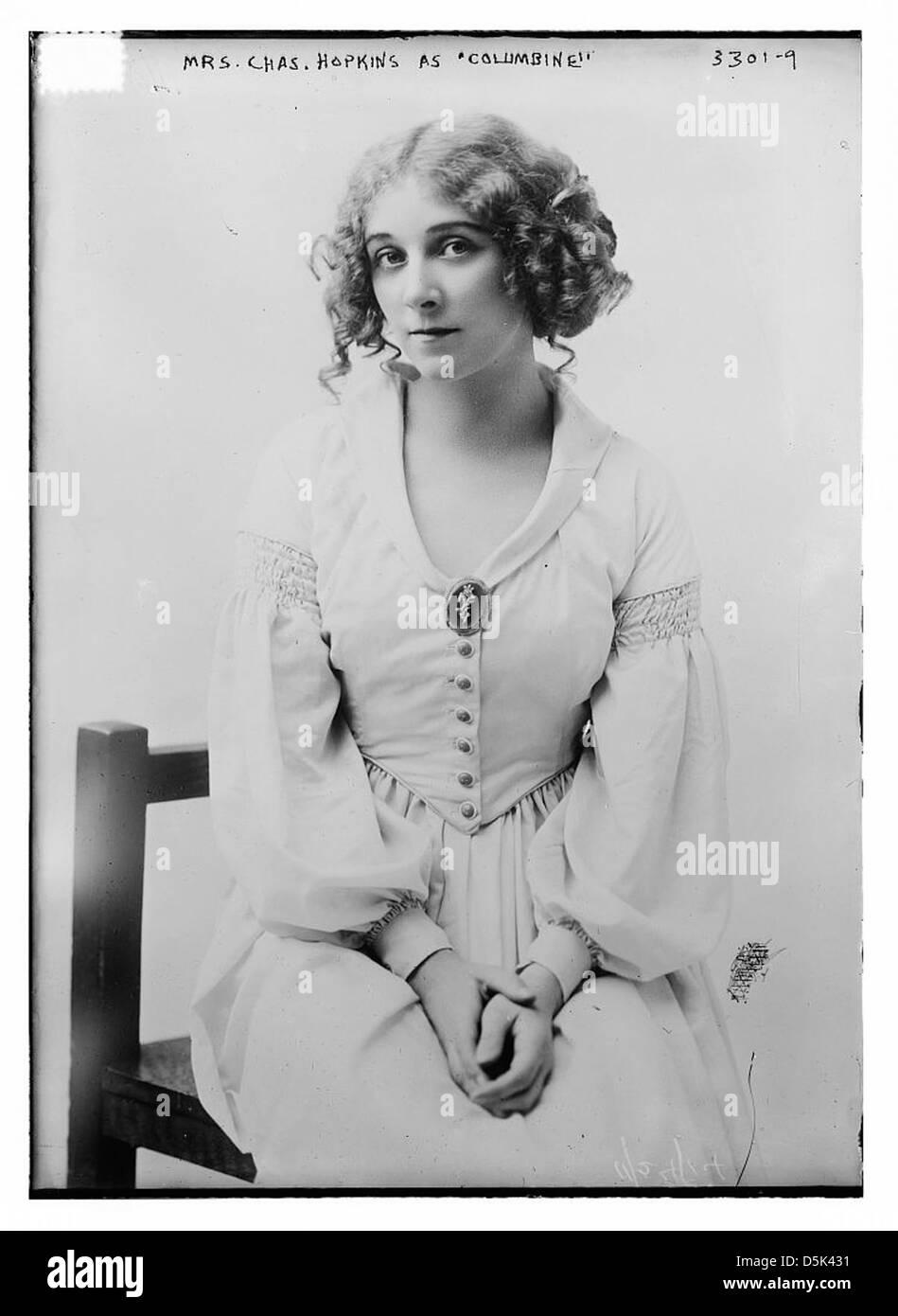 Cette image montre l'actrice MRS Chas Hopkins jouant le rôle de Columbine, un personnage de commedia dell'Arte, dans le cadre d'une représentation théâtrale. La photo la capture en costume avec des boucles distinctives. Banque D'Images