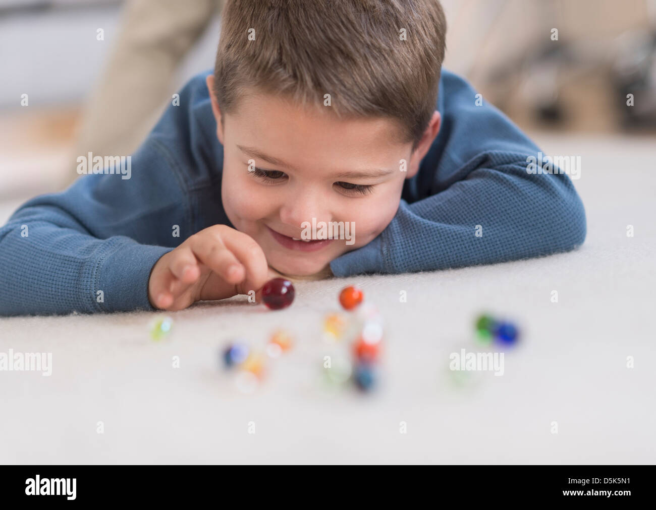 Boy (4-5) jouer avec des billes Banque D'Images