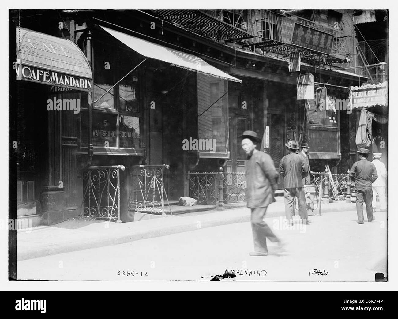 Une photographie de Cafe Mandarin dans Chinatown, New York City, représentant une scène sociale animée. Il montre l'importance de l'emplacement dans la communauté, avec la présence de la Société de sauvetage et du Wah Shung social Club. Banque D'Images