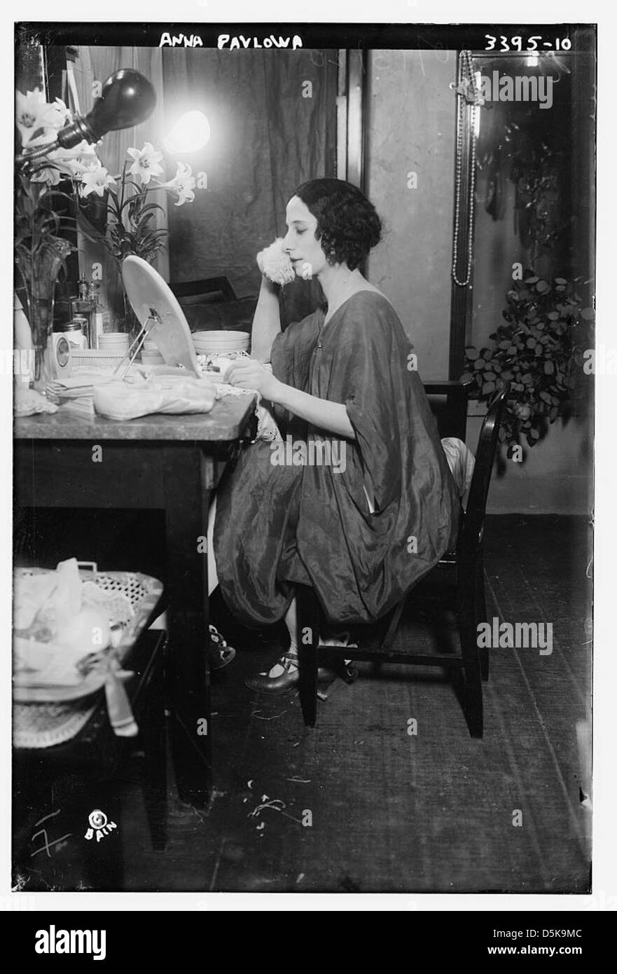 La photographie montre Anna Pavlova, une célèbre ballerine prima russe, connue pour ses performances emblématiques avec les Ballets Russes. Elle est représentée dans une robe de chambre, peut-être avant d'interpréter sa célèbre pièce, "The Dying Swan", un rôle qui a solidifié sa place dans l'histoire du ballet. Banque D'Images