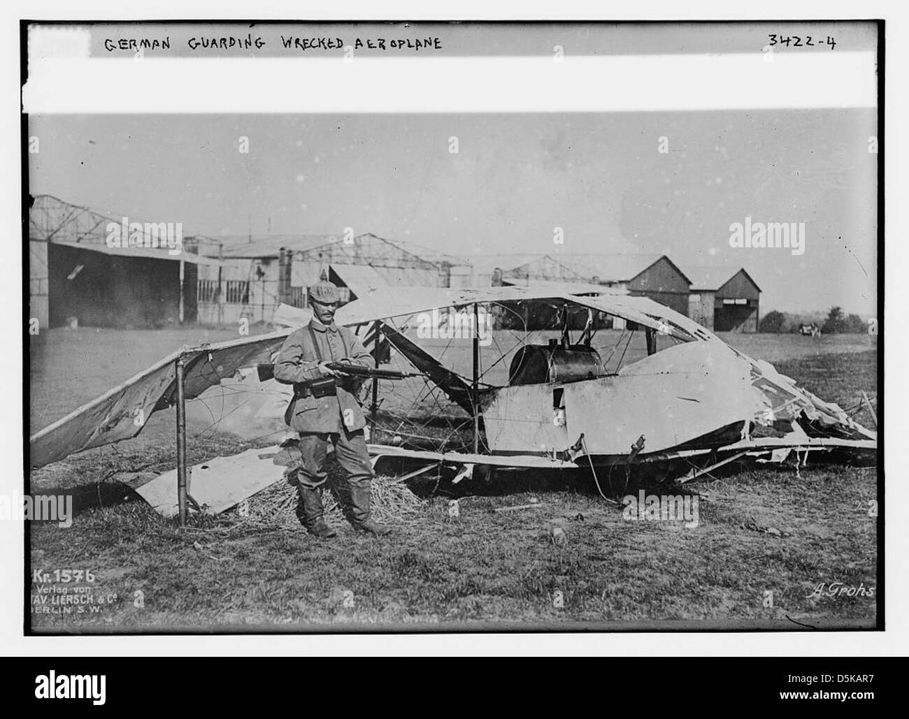 Une photographie de la première Guerre mondiale montrant des soldats allemands gardant un avion naufragé sur un aérodrome, capturant un moment de conflit militaire pendant la Grande Guerre. Banque D'Images
