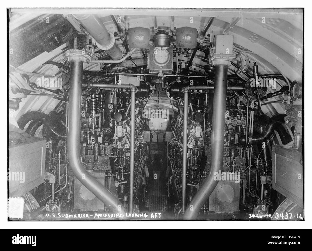 Une photographie de l'intérieur du sous-marin américain G-3, montrant une vue du milieu des navires regardant vers l'arrière. L'image met en évidence les moteurs diesel du sous-marin et d'autres caractéristiques navales, capturant le design intérieur et la technologie militaire du début du XXe siècle. Banque D'Images