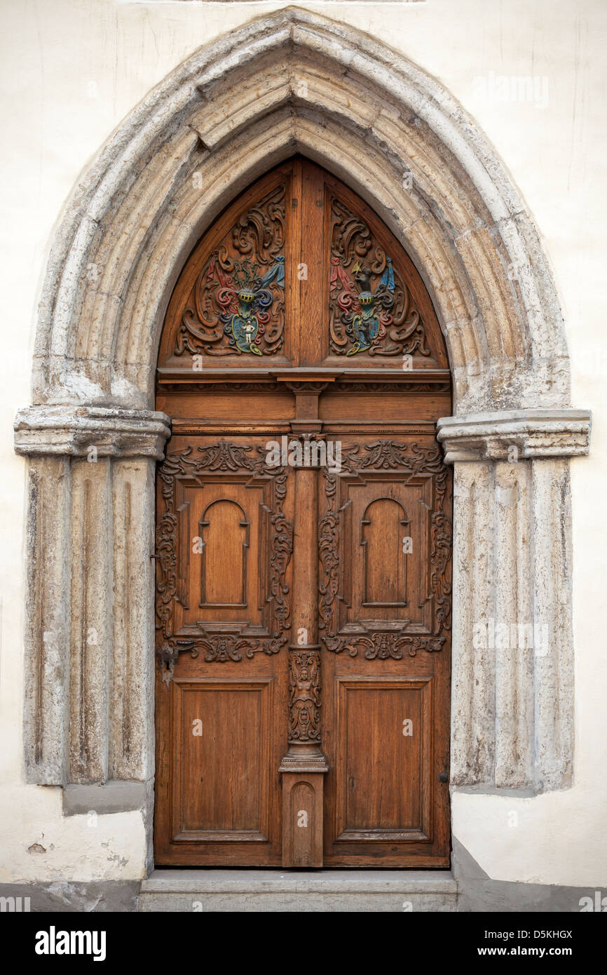 L'ancienne porte en bois sombre avec des éléments de décoration à l'ancienne façade de l'immeuble. Tallinn, Estonie Banque D'Images