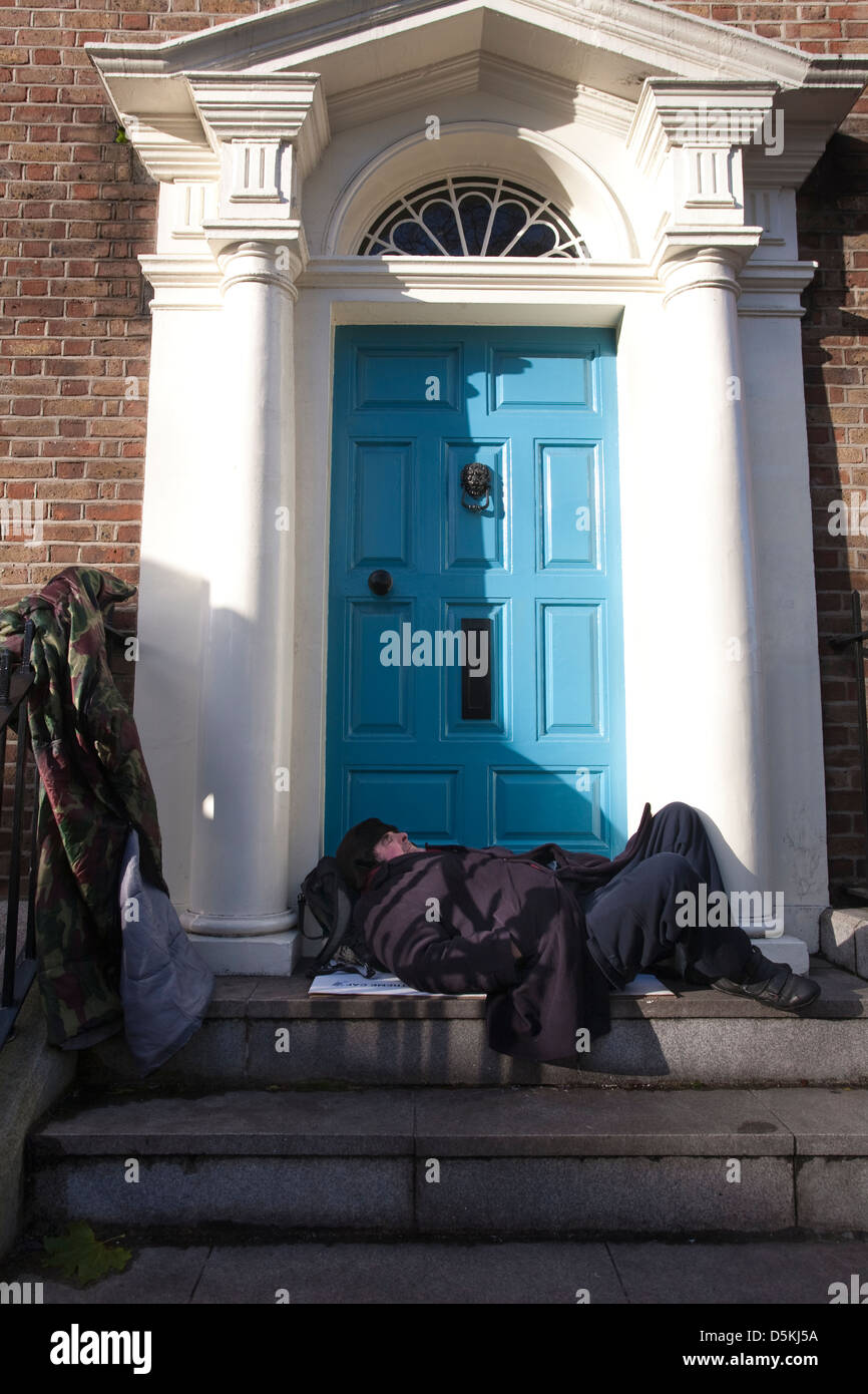 Sans-abri dormir sur une porte en face des bâtiments du gouvernement irlandais sur Kildare Street Dublin en Irlande. Banque D'Images