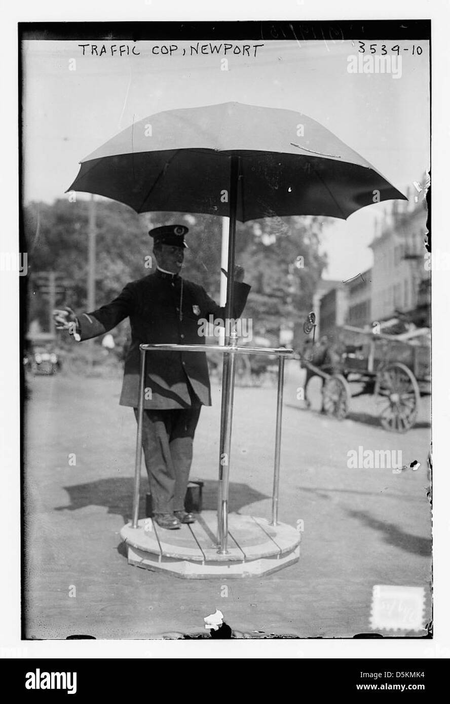 Un policier de la circulation à Newport est montré pour gérer le flux de la circulation avec un parapluie, démontrant le rôle des policiers dans le contrôle de la circulation au début du XXe siècle. Banque D'Images
