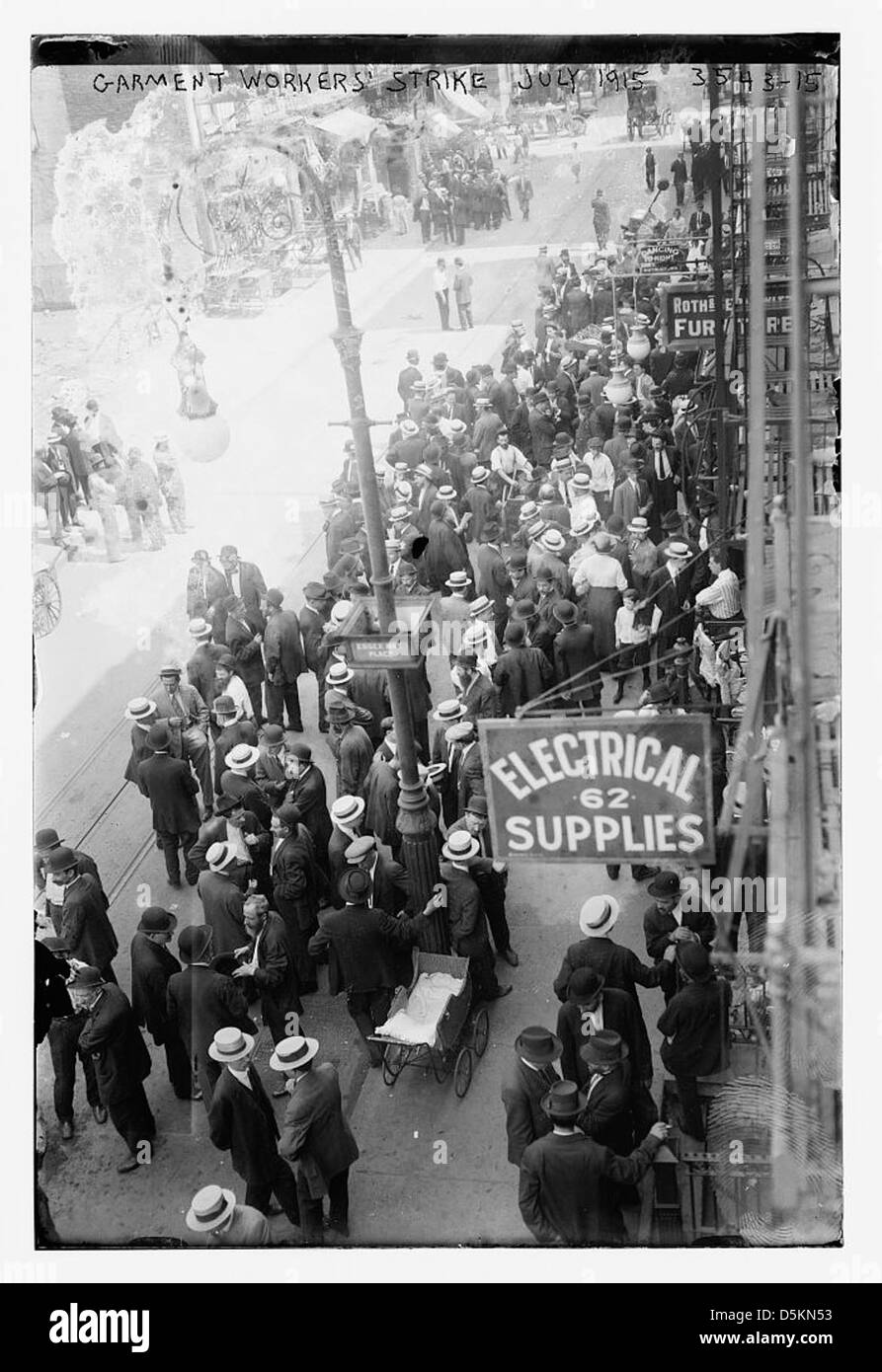 La photographie capture une scène de la grève des ouvriers du vêtement de juillet 1915, un important mouvement ouvrier à New York. On voit des travailleurs participer à la grève pour de meilleures conditions de travail et de meilleurs salaires. Cette manifestation historique met en lumière les luttes ouvrières du début du XXe siècle dans l'industrie du vêtement. Banque D'Images