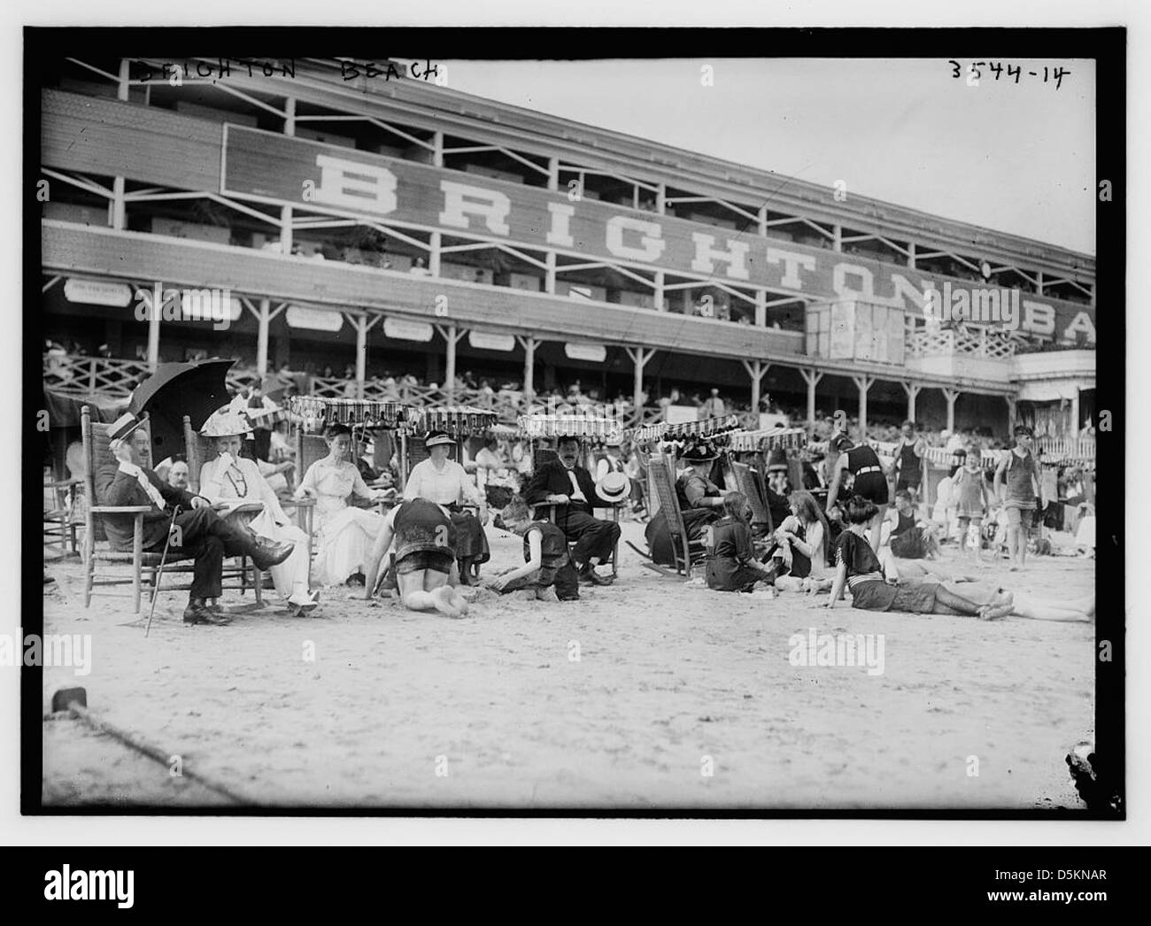 Cette photographie montre Brighton Beach à New York, capturant des bains de soleil sur la plage de sable. L'image met en évidence l'activité de loisirs estivale populaire et l'environnement côtier de la région. Banque D'Images