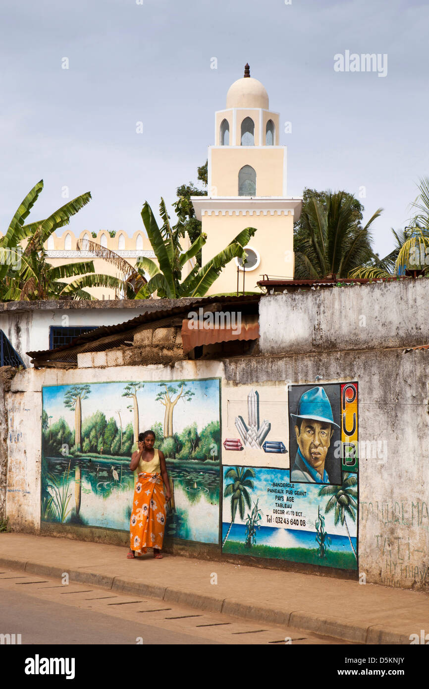 Madagascar, Nosy Be, Be Hell-Ville, rue George V, femme sur téléphone mobile près de mur peint Banque D'Images