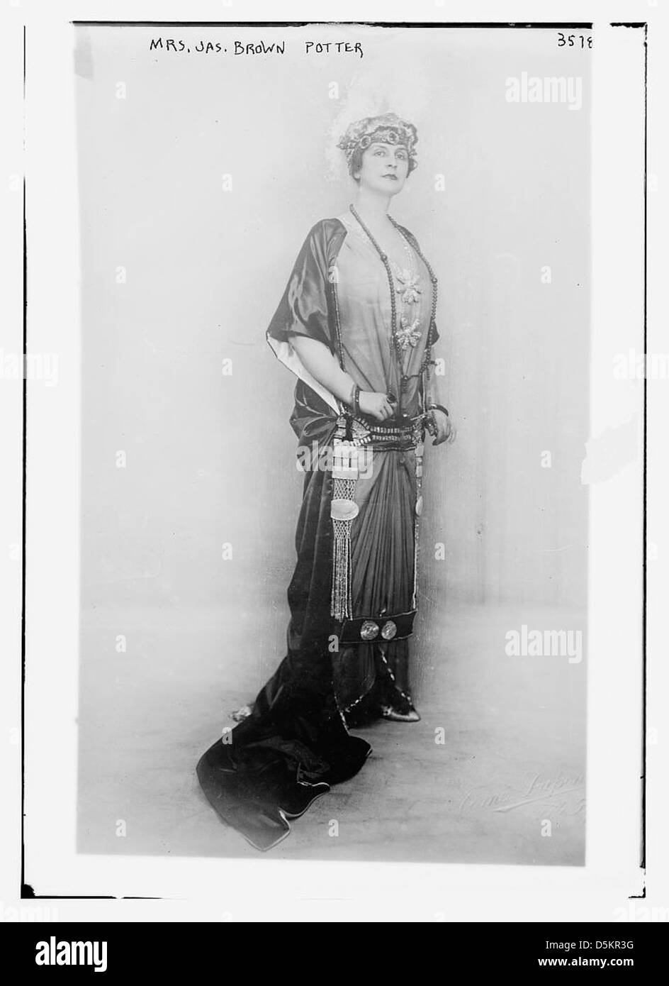 Cette image représente l'actrice MRS Jas Brown Potter dans une pose debout royale, vêtue d'un costume élaboré. La photographie est une représentation historique de la mode théâtrale du début du XXe siècle. Banque D'Images