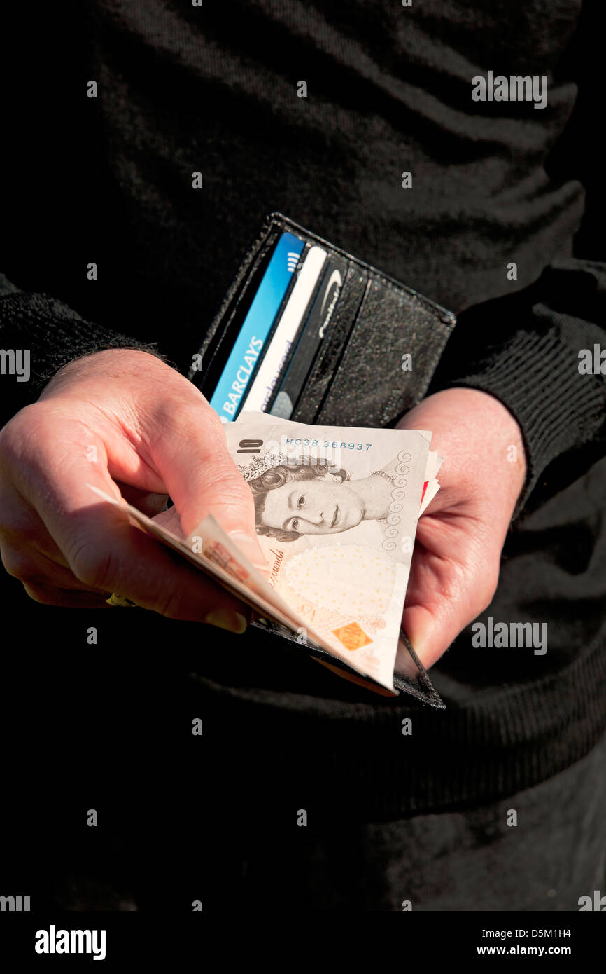 Gros plan d'un homme détenant Lend Lending Lorow emprunt portefeuille et billets de dix livres sterling 10 livres sterling British Money cash England UK Banque D'Images
