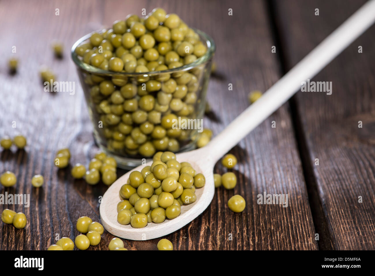 Petits pois sur une cuillère en bois (macro shot) Banque D'Images