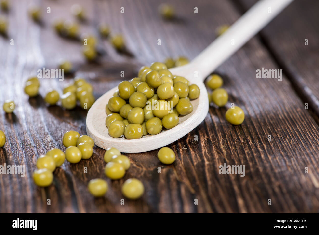Petits pois sur une cuillère en bois (macro shot) Banque D'Images