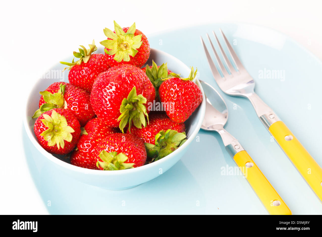 Les fraises dans une plaque turquoise Banque D'Images