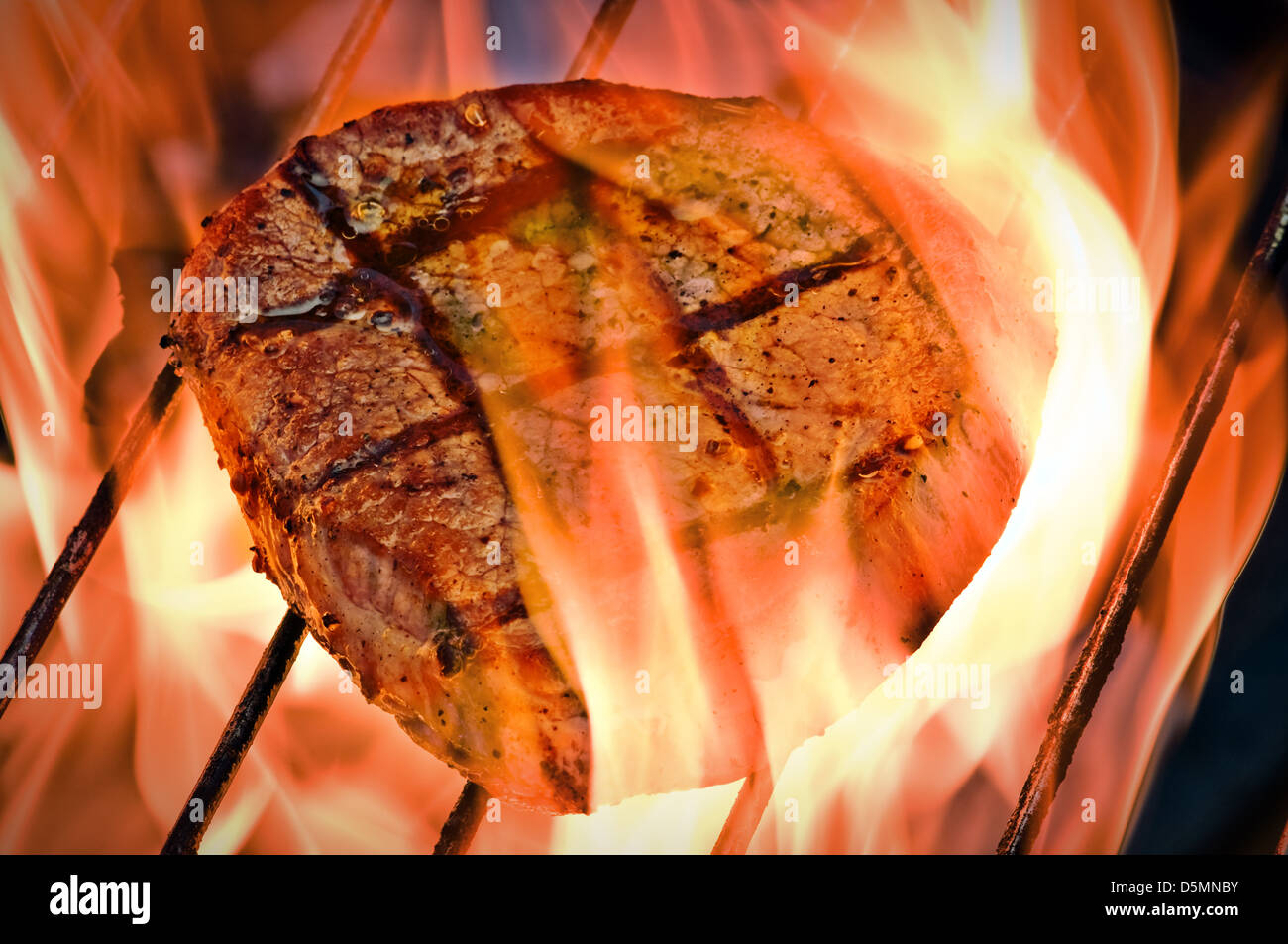 Le bifteck sur le grill bar rayé fiery closeup Banque D'Images