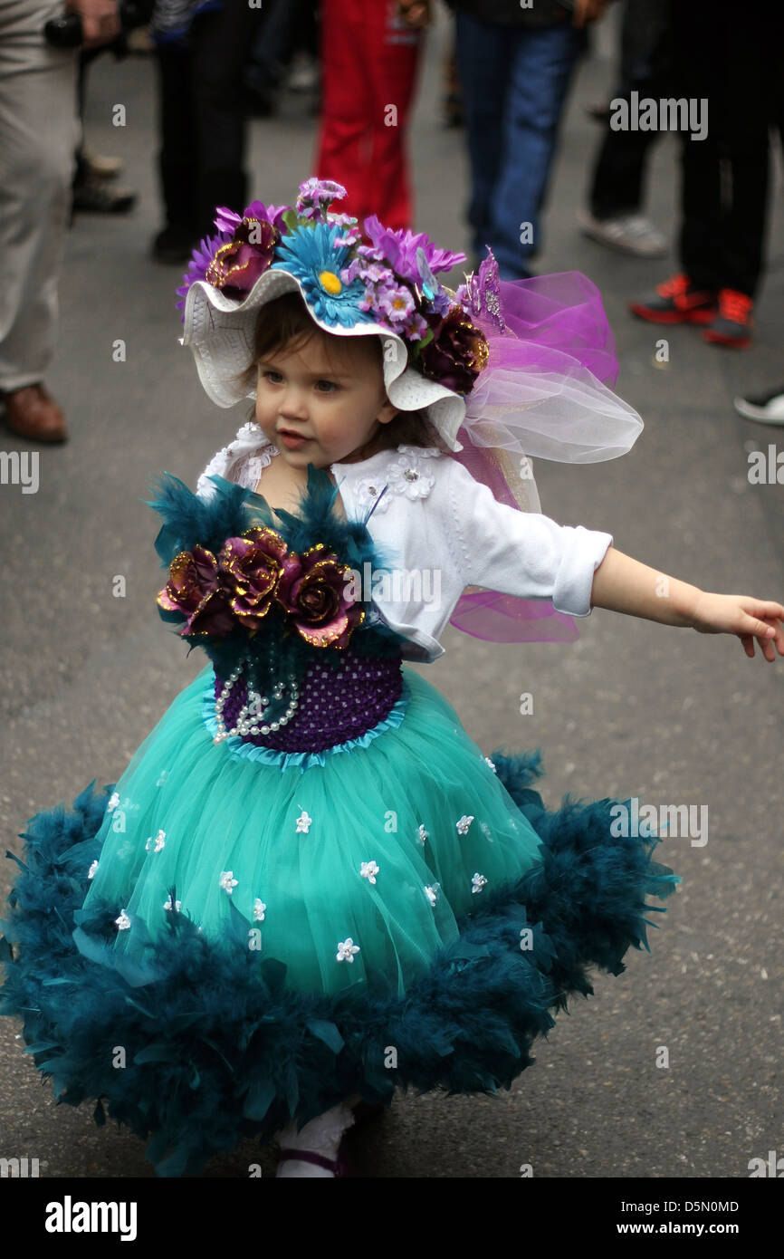 Une petite fille dans une robe et un chapeau fait un spectacle de danse improvisée à la New York City's Easter Parade Banque D'Images