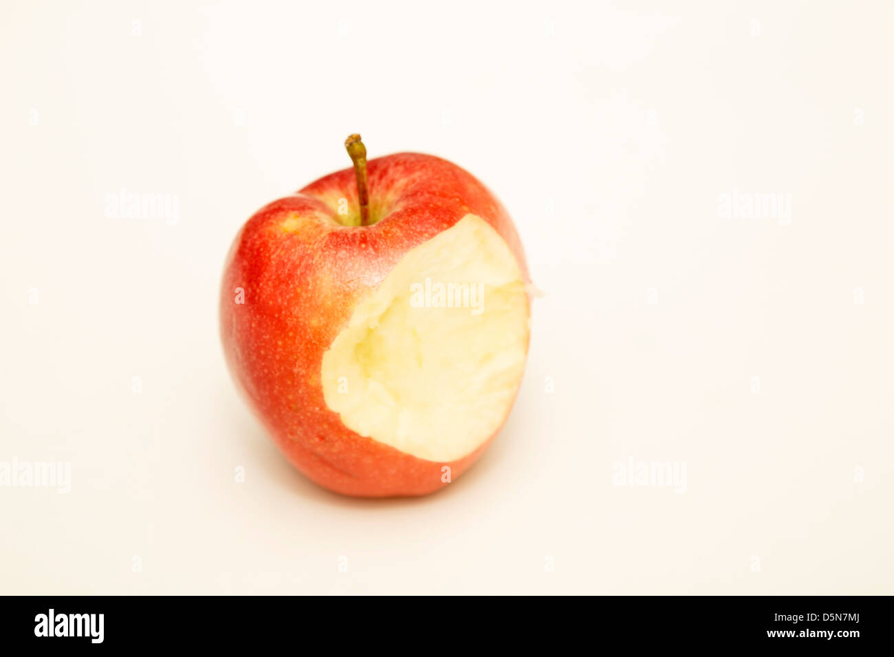 Une seule pomme rouge sur fond blanc avec compteur manquant morsure Banque D'Images