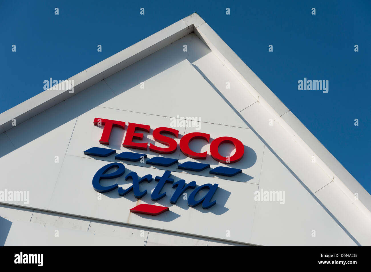 Détail d'un immeuble supplémentaire tescos toit avec logo et inscription Huntingdon UK against a blue sky Banque D'Images