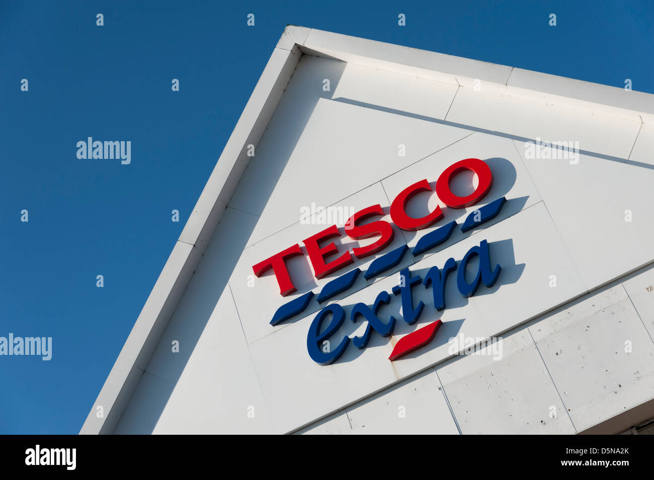 Détail d'un immeuble supplémentaire tescos toit avec logo et inscription Huntingdon UK against a blue sky Banque D'Images